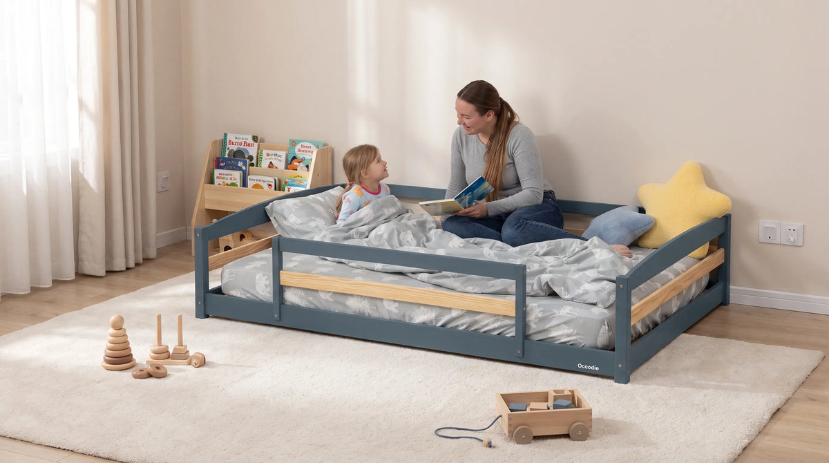 A low Montessori floor bed frame with guardrails, a snug mattress and open floor space in a childproof bedroom.